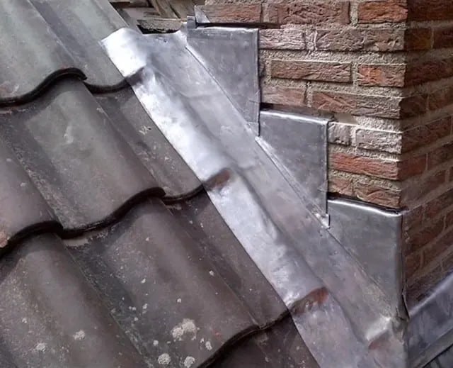Vakkundig loodwerk op aansluiting van pannendak en muur