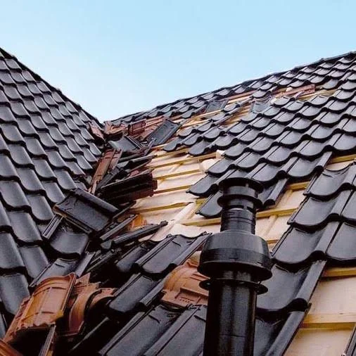 Losgeraakte dakpannen door stormschade met zichtbare dakconstructie